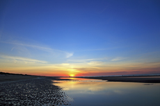 Ameland-Holland<br />Der glühende Sonnenuntergang wirft tiefe Schatten auf dem nördlichen Seestrand von Ameland.